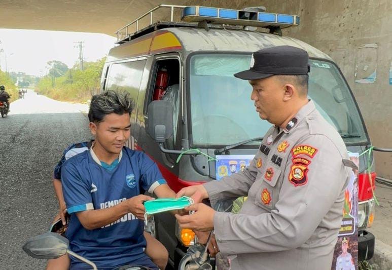 Cegah Dampak Kabut Asap, Satbinmas Polres OKI Bagikan Masker kepada Warga dan Pengguna Jalan