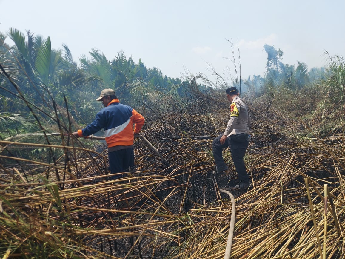 Bhabinkamtibmas Bersama Masyarakat Tangani Karhutla di Desa Teluk Payo