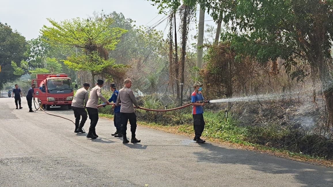 Respon Cepat Polres OKU Bersama Damkar Padamkan Kebakaran Lahan di Jalan Lintas Batukuning